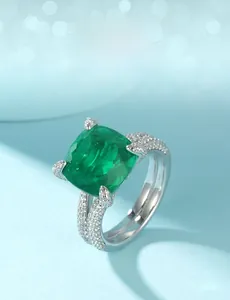 Macro shot of cushion cut emerald green stone ring with white cubic zirconia pavé