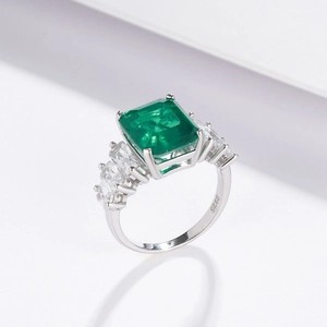 Rectangle emerald ring in S925 sterling silver with side stones on a white background
