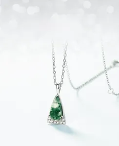 Macro detail of teardrop moss agate pendant with sparkling crystals on S925 silver chain