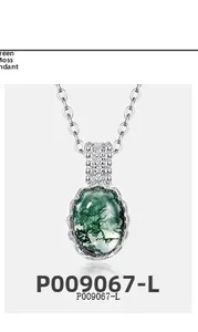 Macro detail of oval green moss agate pendant in 925 sterling silver with small diamonds