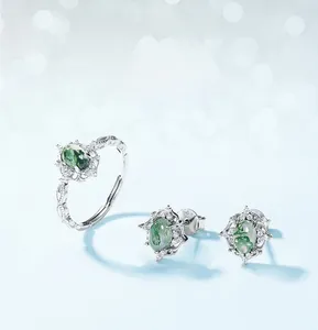 Detail of S925 silver jewelry set with oval green moss agate stones and zircon floral frame