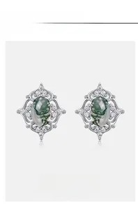Detail shot of oval moss agate earrings with vintage silver frame and zircon accents