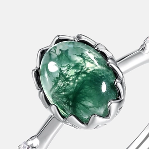 Natural moss agate s925 silver ring with sparkling side stones on a neutral background