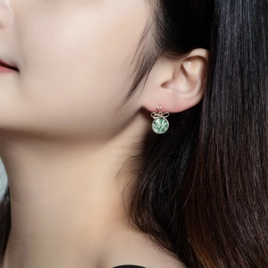 Elegant moss agate bow earrings with S925 silver and round green gemstone on a model