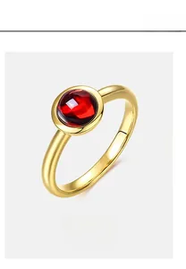 Macro shot of minimalist S925 silver 10K gold plated ring with round red cabochon gem