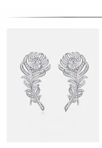 Macro detail of silver feather earrings with pink carbon diamonds and white gemstones