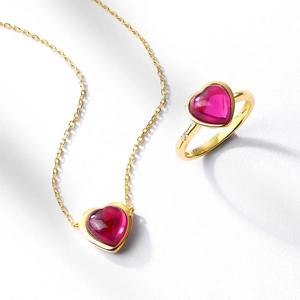S925 silver heart ruby necklace and ring set with 10K gold plating on white surface
