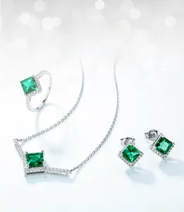 Detail view of princess cut lab-grown emerald jewelry set with ring necklace and earrings