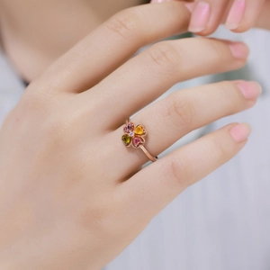 Rose gold four-leaf clover ring with heart-shaped pink, yellow, and green gemstones