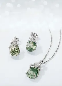 Close-up of moss agate pendant and earrings set featuring a silver snake design
