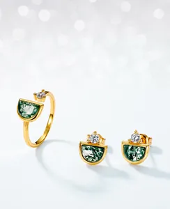 Macro view of gold plated jewelry set featuring green moss agate stones and cubic zirconia