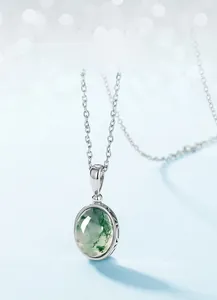 Macro shot of oval green moss agate pendant with S925 silver claw setting and texture