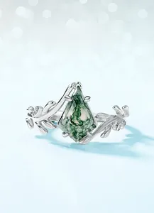 Macro detail of moss agate ring featuring olive branch silver band and diamond accents
