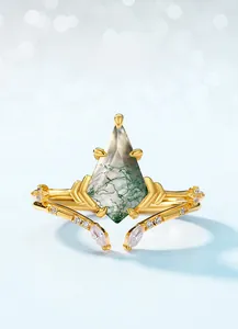 Macro detail of moss agate ring with twig band and kite-cut gemstone on blue backdrop