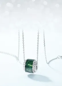 Détail macro du pendentif en agate mousse naturelle sur une fine chaîne en argent