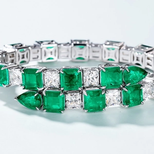 Luxury S925 silver bangle featuring emerald-cut green gems and white square crystals