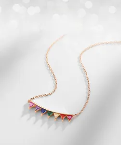 Macro shot of triangle-cut rainbow cubic zirconia pendants on a rose gold S925 silver chain