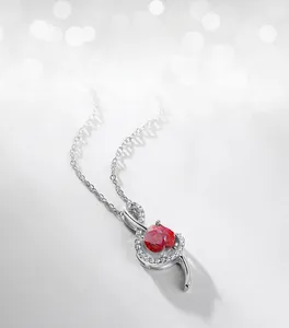 Macro detail of silver musical note pendant with ruby and sparkling white zircons