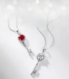 Detailed view of key-shaped silver pendants with red and white gemstone accents