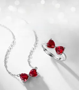 Macro detail of the heart-shaped red gemstone bow knot ring and matching necklace set