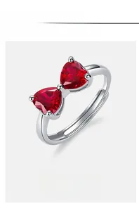 Macro shot of silver bow ring with red heart rubies on an adjustable band detail