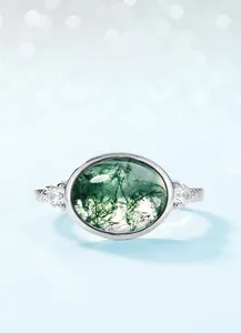 Macro detail of oval moss agate ring with vintage silver setting and side stones
