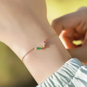 Bracciale arcobaleno con finitura dorata e cristalli multicolore sul polso femminile