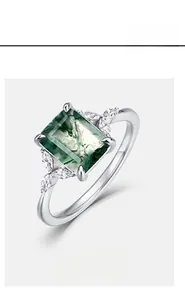 Macro shot of rectangular green moss agate ring with marquise side stones on silver band