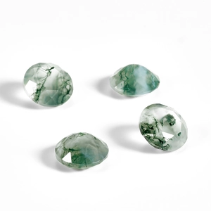 Macro shot of faceted natural green moss agate gemstones with translucent tree-like inclusions