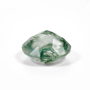 Macro view of faceted natural moss agate gemstone with green mineral inclusions