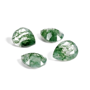 Macro detail of four pear-cut natural moss agate gemstones with green mossy textures