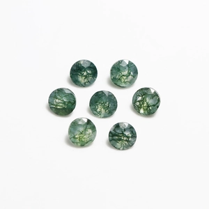 Detailed macro view of seven faceted round moss agate gemstones on a white background