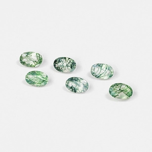 Set of six oval faceted moss agate gemstones with natural green moss inclusions on white