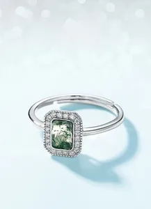 Détail macro de l'agate mousse rectangulaire avec halo scintillant sur bague argent