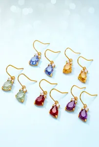 Macro shot of colorful teardrop crystals with gold ear hooks in five vibrant colors