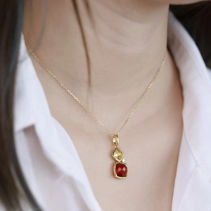 Detailed view of a gold S925 necklace featuring vertical square red and yellow gemstones