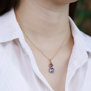 Close-up of double-tiered square gemstone pendant necklace in blue and burgundy