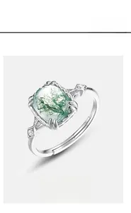 Macro shot of silver ring with square green moss agate and side zircon accents