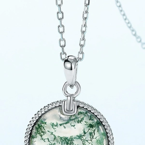 Vue macro d'un pendentif en agate mousse naturelle avec cadre en argent S925 torsadé