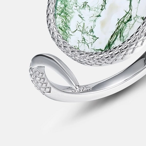 Macro shot of S925 silver stamp and mesh hollow texture on a green moss agate ring