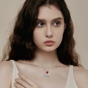 Elegant S925 silver heart MOM necklace with red gemstone worn by a model in soft light