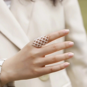 Hollow geometric grid statement ring in shiny silver finish worn on index finger