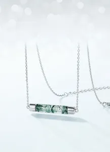 Detail shot of the cylindrical green moss agate pendant on a S925 silver chain necklace
