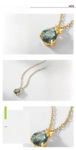 Macro detail of teardrop moss agate pendant with golden butterfly accent and silver base