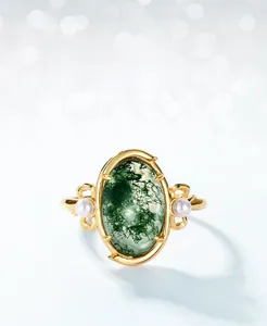 Macro detail of moss agate ring with oval gemstone and two small pearl accents