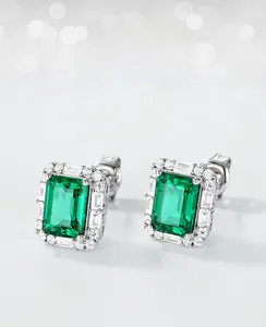 Detailed view of emerald stud earrings with rectangular cut stones and silver settings
