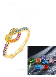 Detailed macro view of rainbow cubic zirconia stones in a gold infinity knot ring setting