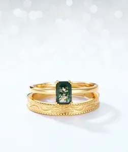 Macro detail of rectangle moss agate stone and engraved gold band stackable rings