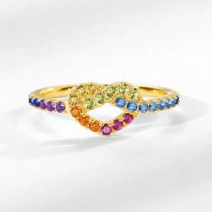 Gold infinity heart ring with rainbow gradient cubic zirconia on grey background