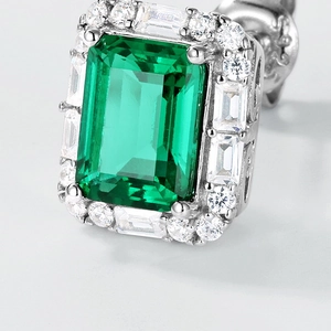 Macro view of geometric emerald stud with halo baguette diamond setting in 925 silver